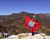 Alumna Taylor Baumgarten, who earned a degree in public health, holds a UA flag at the Great Wall of China. Alumna Taylor Baumgarten, who earned a degree in public health, holds a UA flag at the Great Wall of China.
